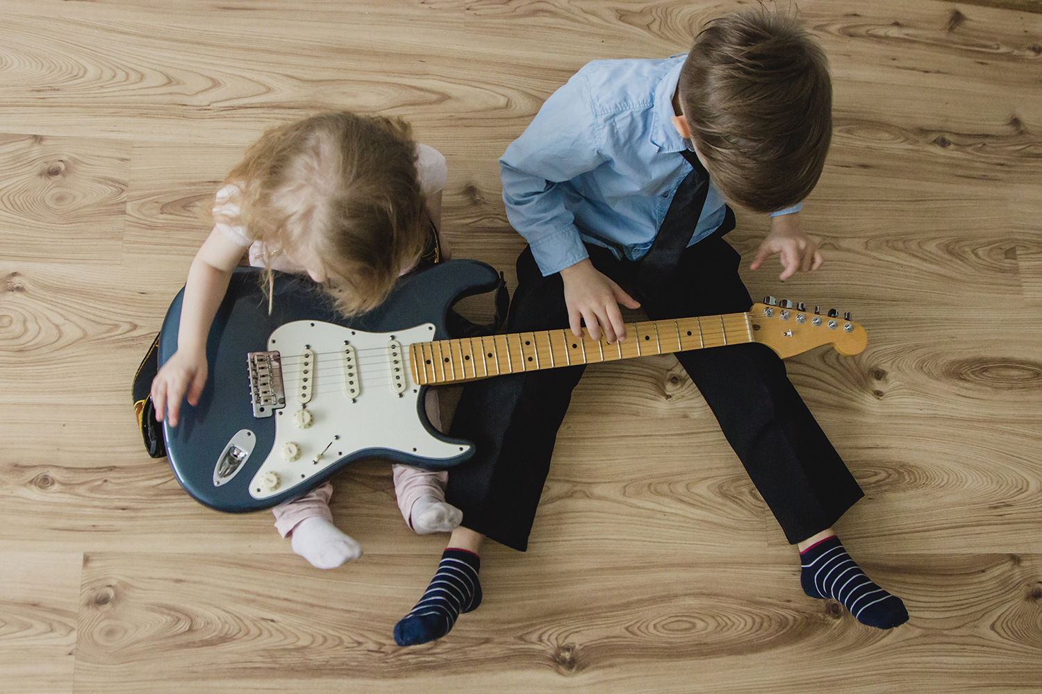 Niños intentando tocar la guitarra eléctrica